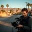 Ragas Khatwani preparing a camera beside a desert street before a news assignment